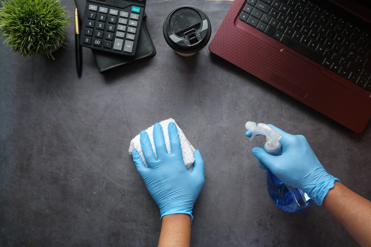 Cleaning workspace with wipes and liquid spray